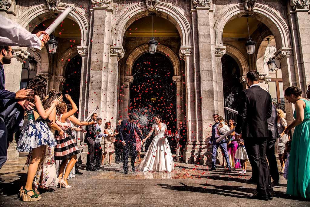 Fotografia de boda a la puerta del ayuntamiento de Valladolid, los invitados tirando arroz a los novios